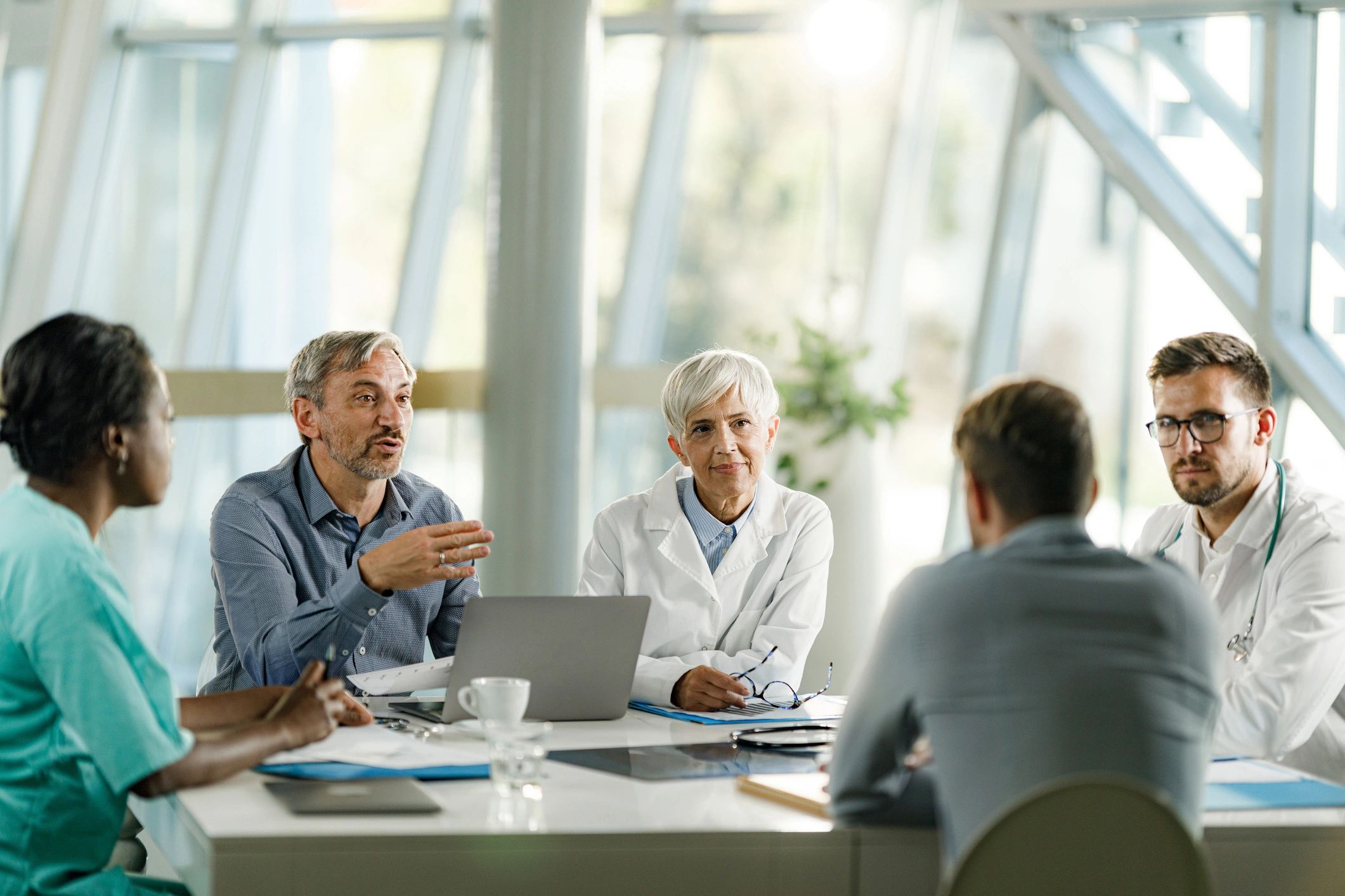 Healthcare professionals and business leaders meeting in a medical office.