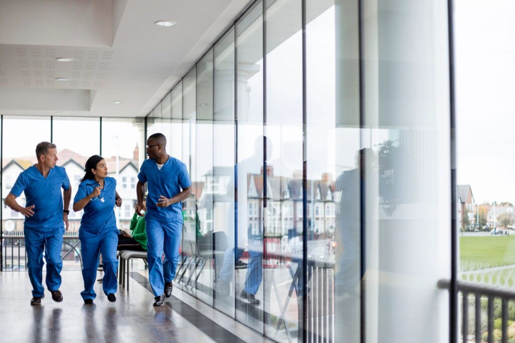Healthcare operations team moving quickly through a clinical corridor